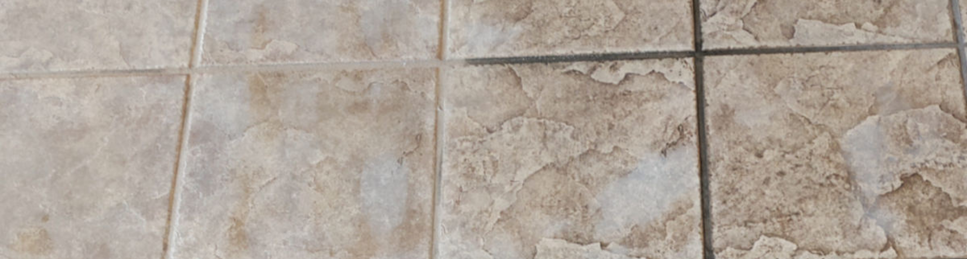 Side-by-side image of dirty, black tile grout next to sparkling clean, sealed white tile grout, demonstrating professional tile restoration results.