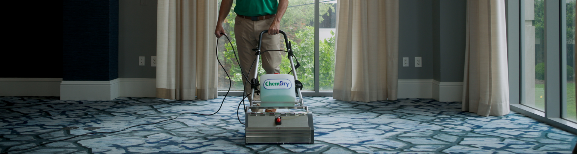 A technician cleaning a large, high-traffic carpet area in a modern, professional office building after business hours in Fort Wayne.